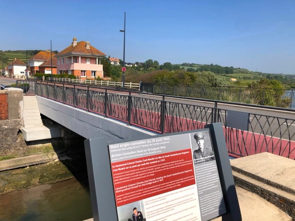 A bilingual interpretive panel describing the raid of 19 August 1942, beside the road bridge over the river at Pourville