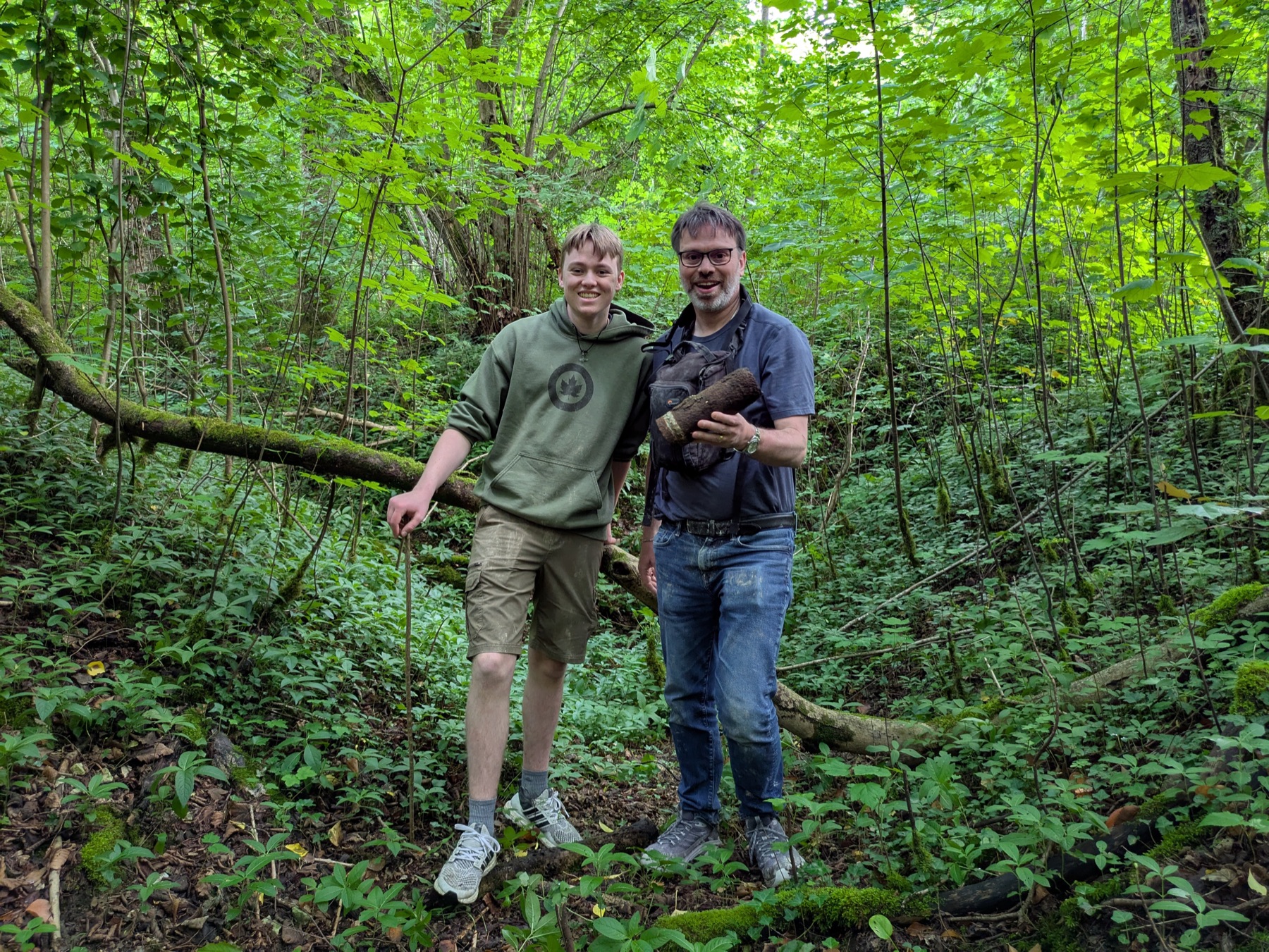 Two guests pause together on a forest trail during a multi-day tour