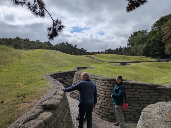 A guide and guest walking through the preserved trenches and mine craters at Vimy Ridge
